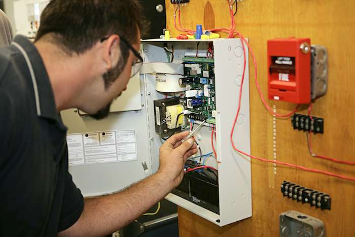 man performing fire alarm service